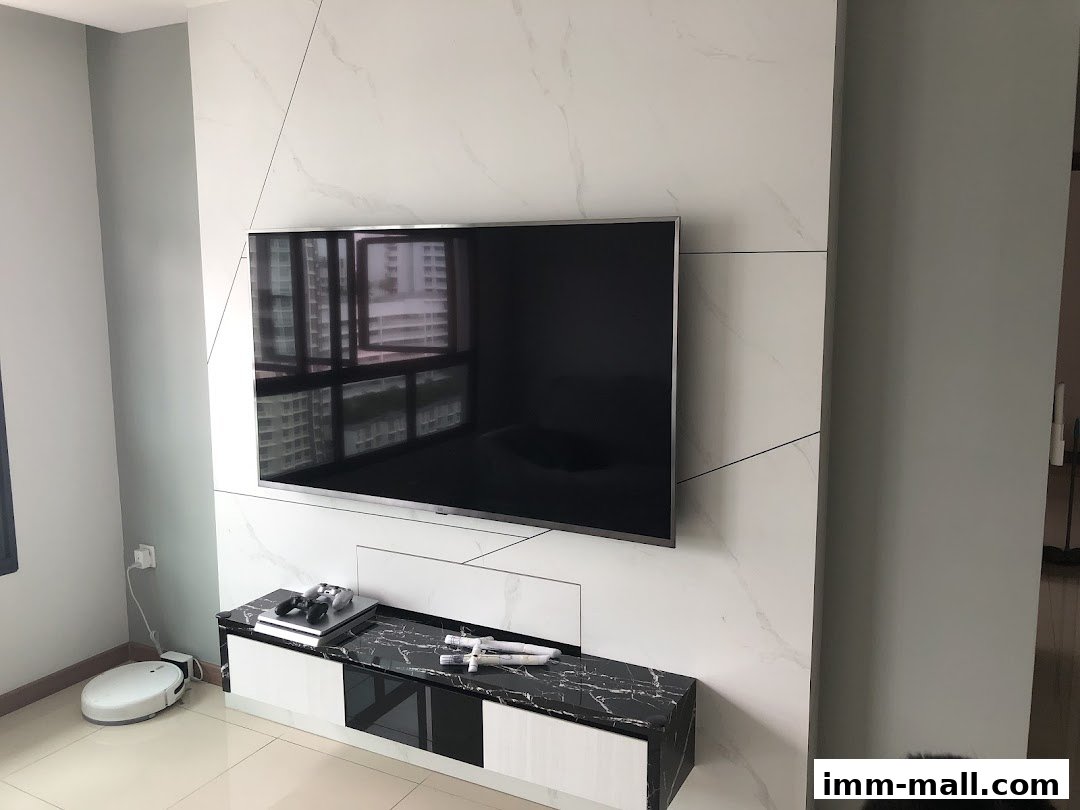 A modern living room featuring a large TV mounted on a marble-patterned wall with a sleek media console.