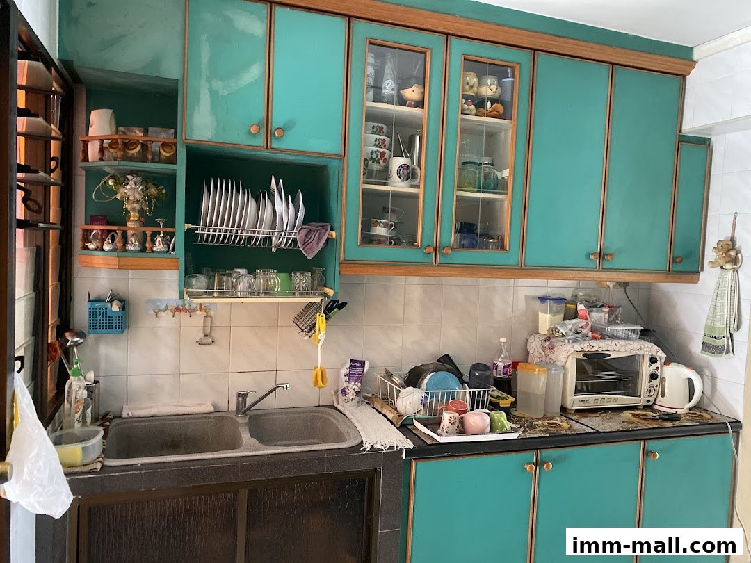 A kitchen sink area with turquoise cabinets, dishes, and appliances.