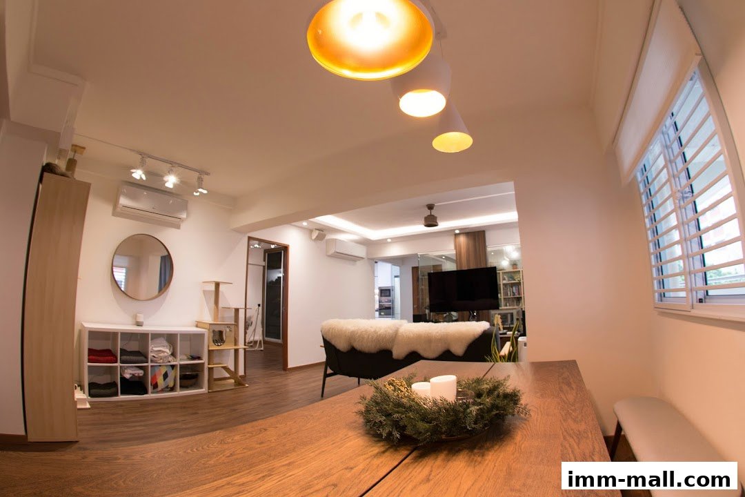 A modern living room with a dining table, sofa, and shelves, featuring stylish lighting.