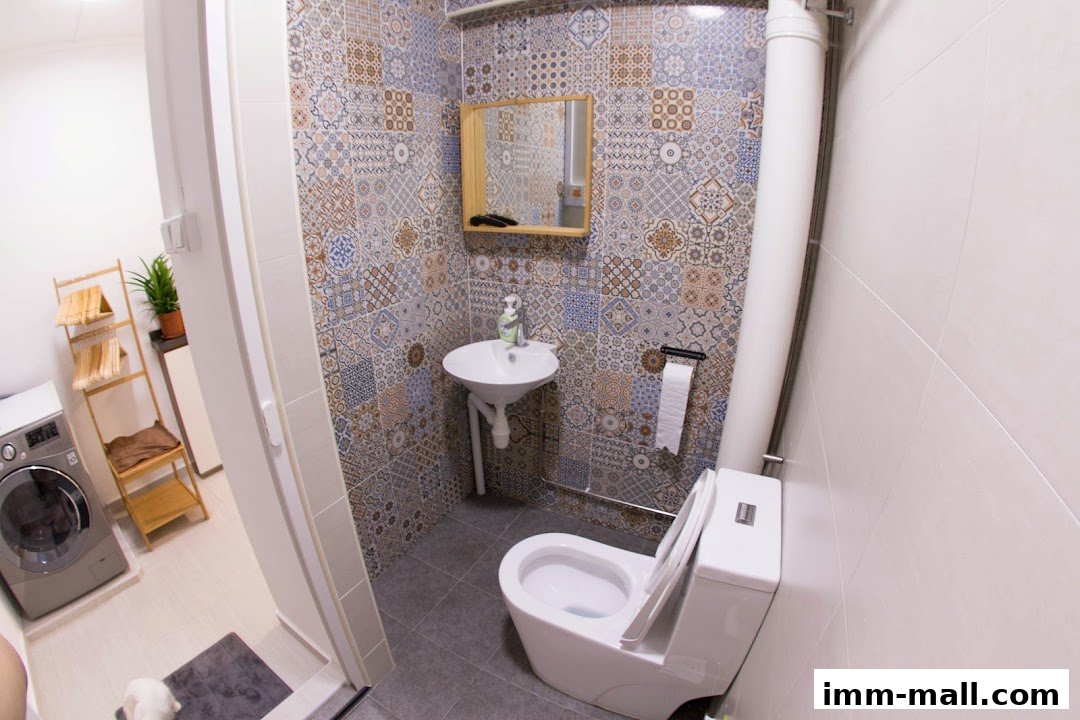 A modern bathroom with a washing machine, sink, and toilet, featuring patterned tiles.