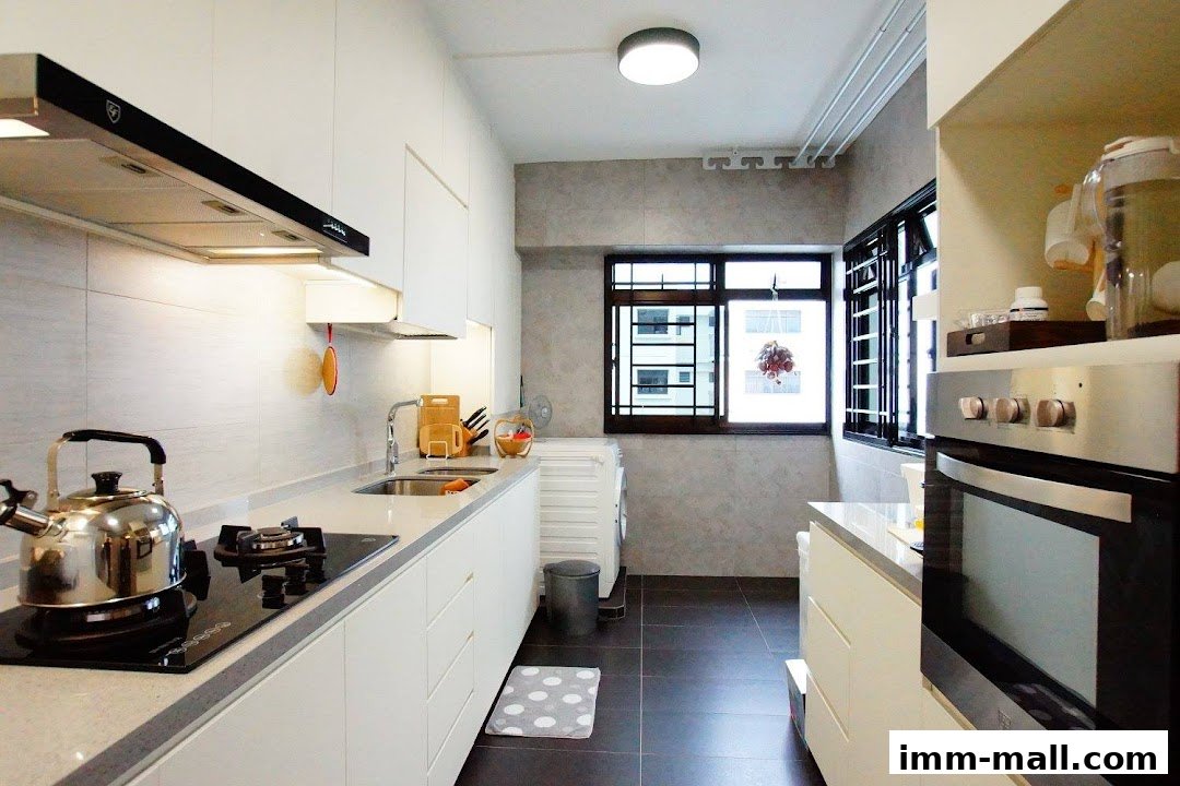 A modern, clean kitchen with white cabinets, a gas stove, sink, and oven.
