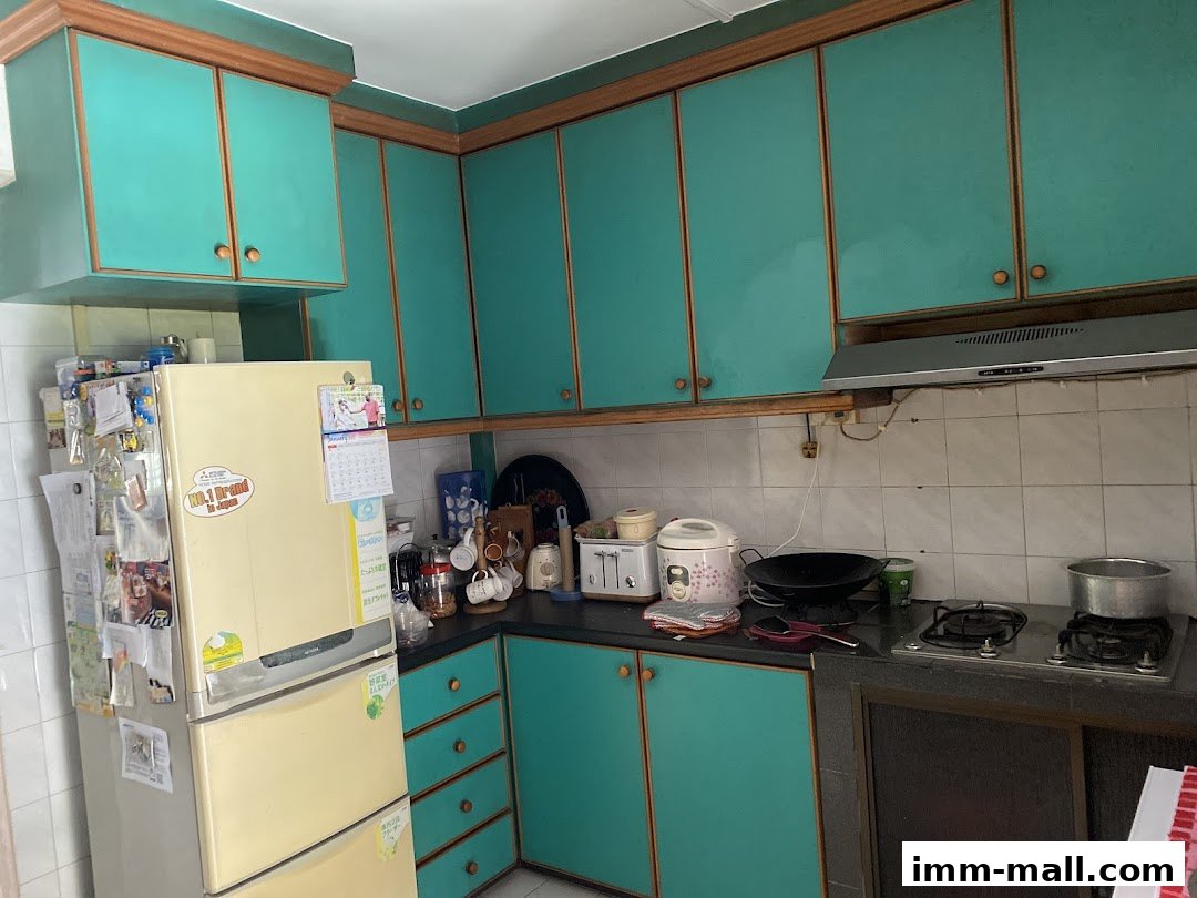 A kitchen interior featuring teal cabinets, a refrigerator, and cooking appliances.