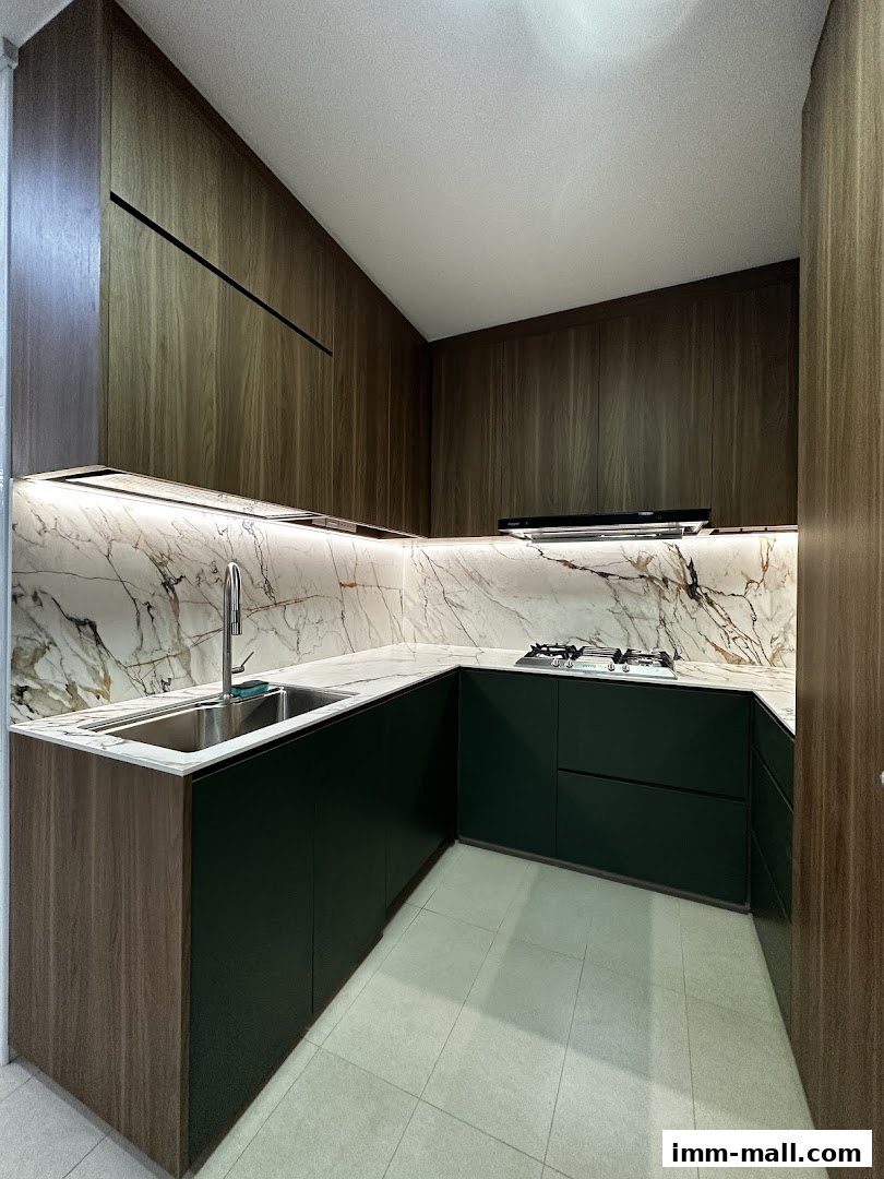 A modern kitchen with dark green cabinets, marble backsplash, and wooden accents.