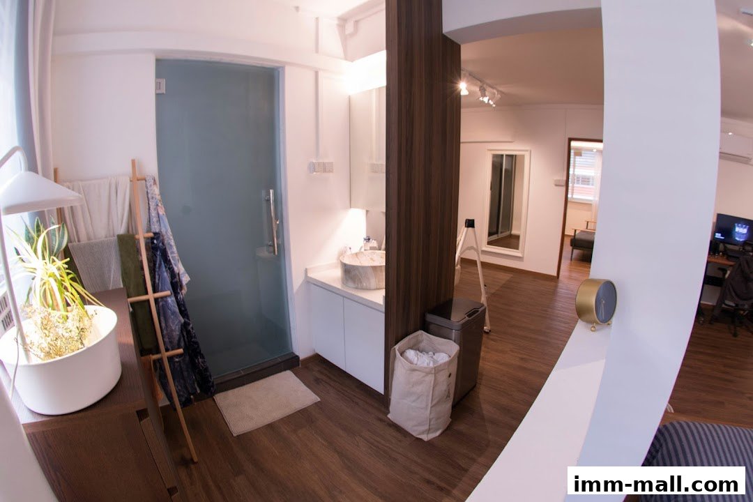Interior view of a modern bathroom and adjacent living space with a desk and computer.