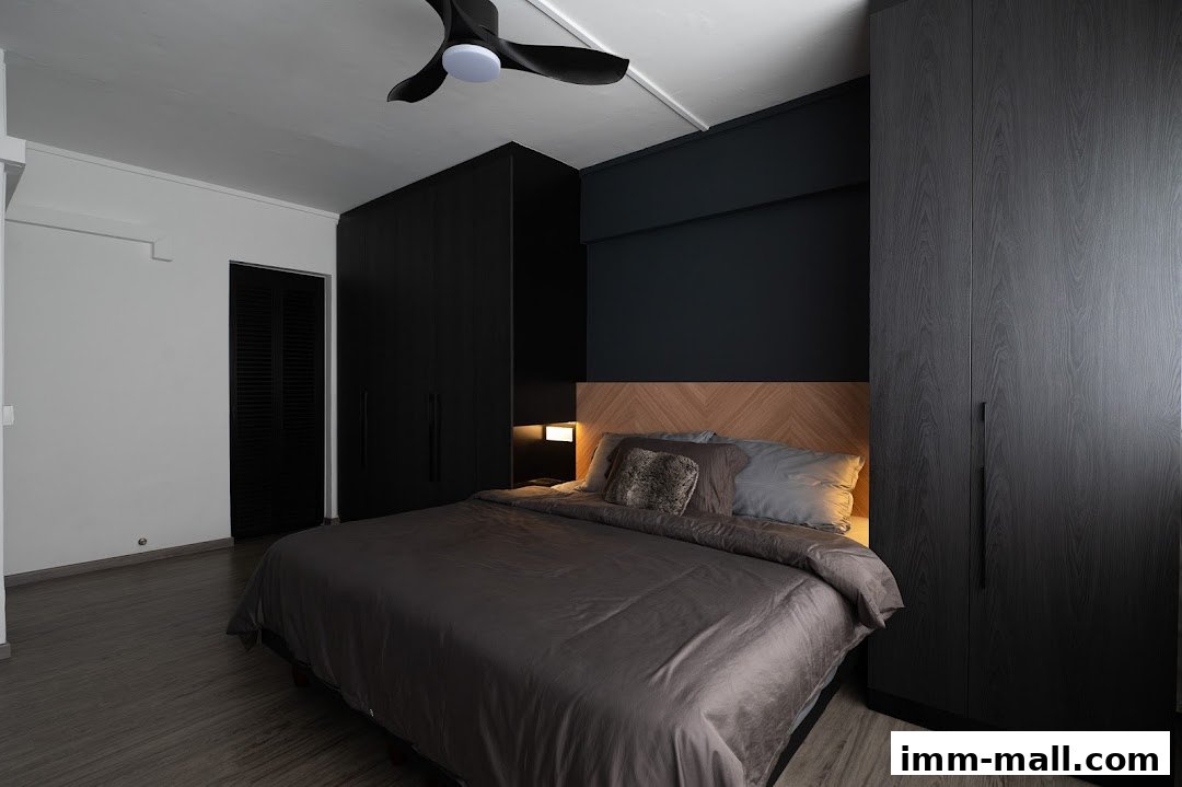 A modern bedroom with a king-size bed, dark wardrobes, and a ceiling fan.