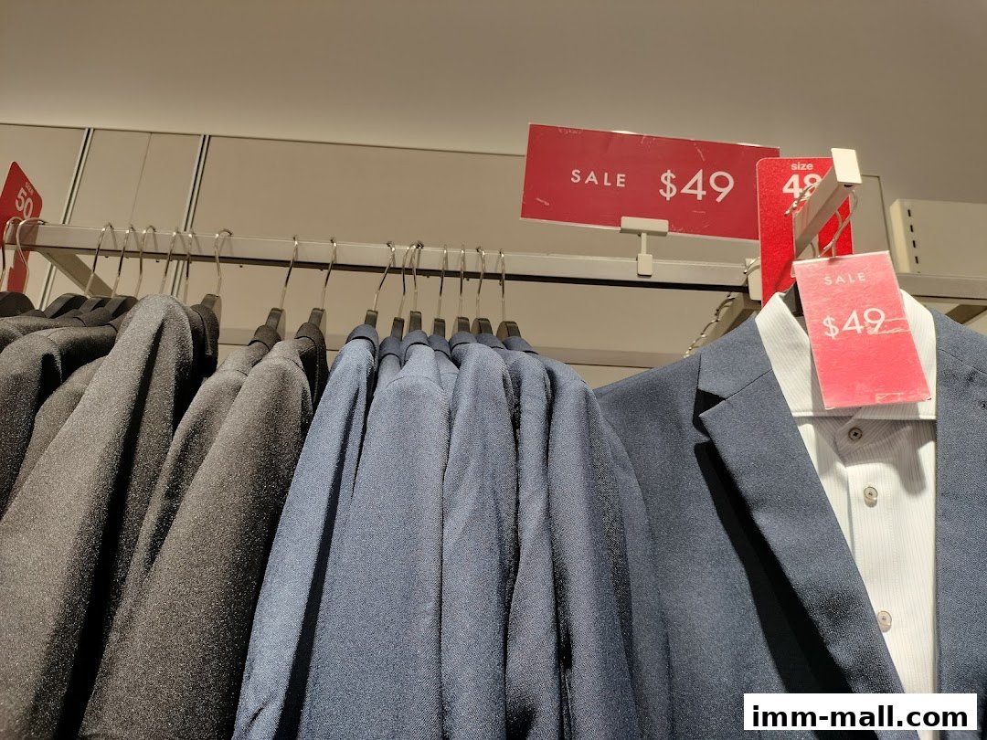 A rack of men's suits and shirts with sale tags indicating $49.