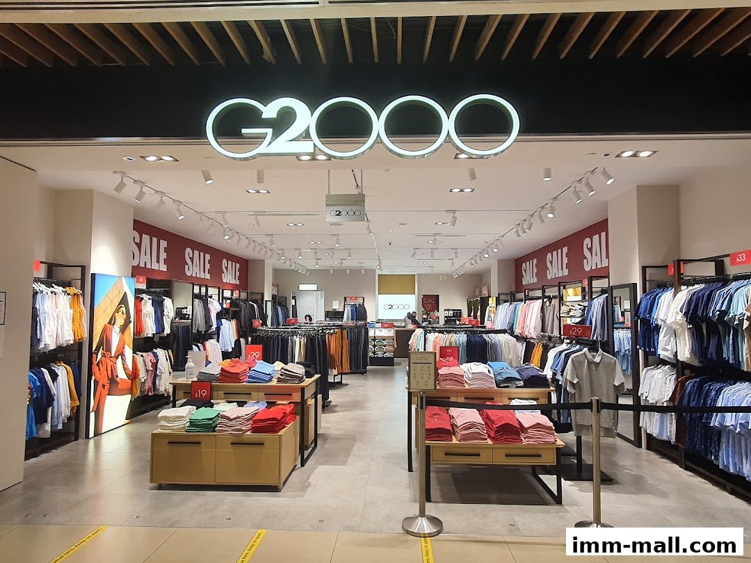 The G2000 store entrance displays a wide selection of men's and women's apparel on sale.