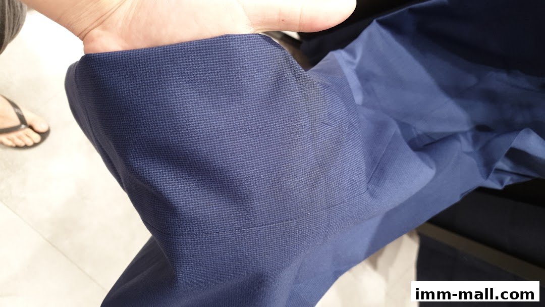 Close-up of a person's hand holding a navy blue patterned fabric.