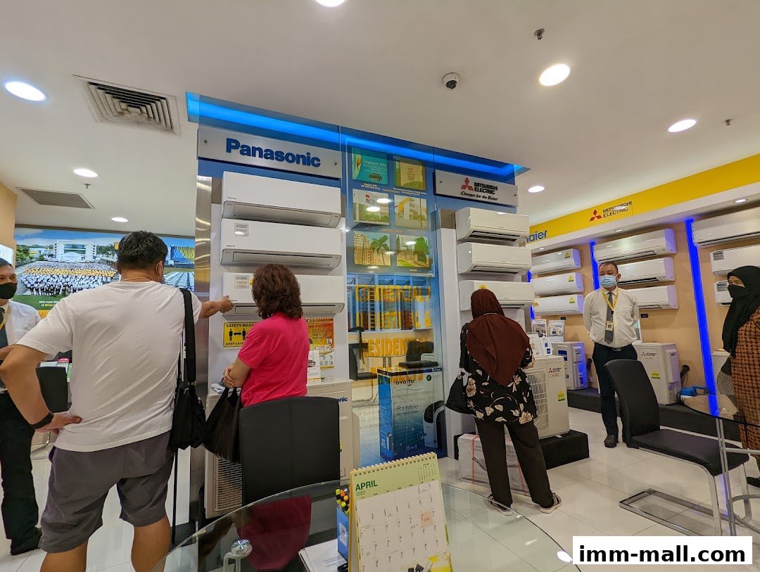 Customers browse air conditioning units at Gain City, with Panasonic and Mitsubishi Electric displays.
