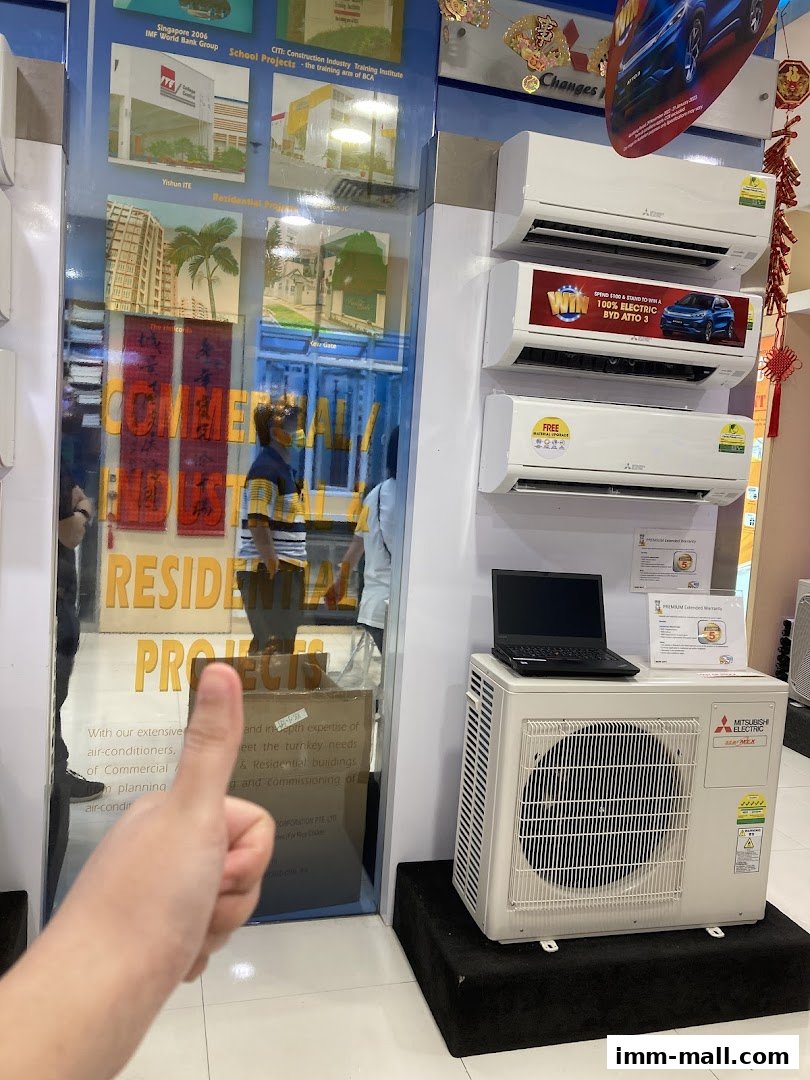A display of Mitsubishi Electric air conditioners with a laptop on an outdoor unit.