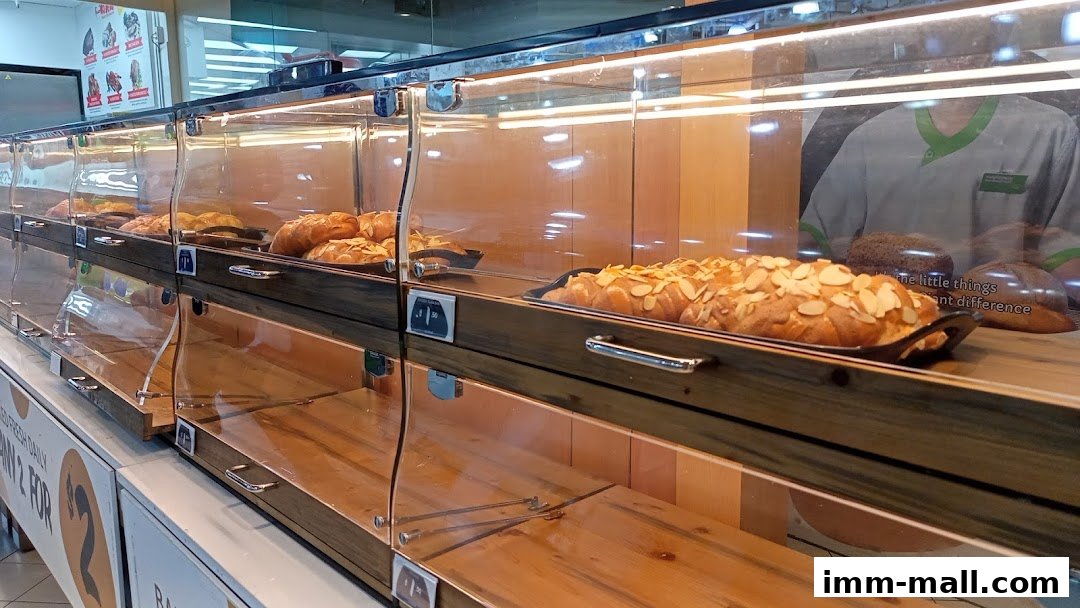 A display case filled with freshly baked bread and pastries, some topped with almonds.