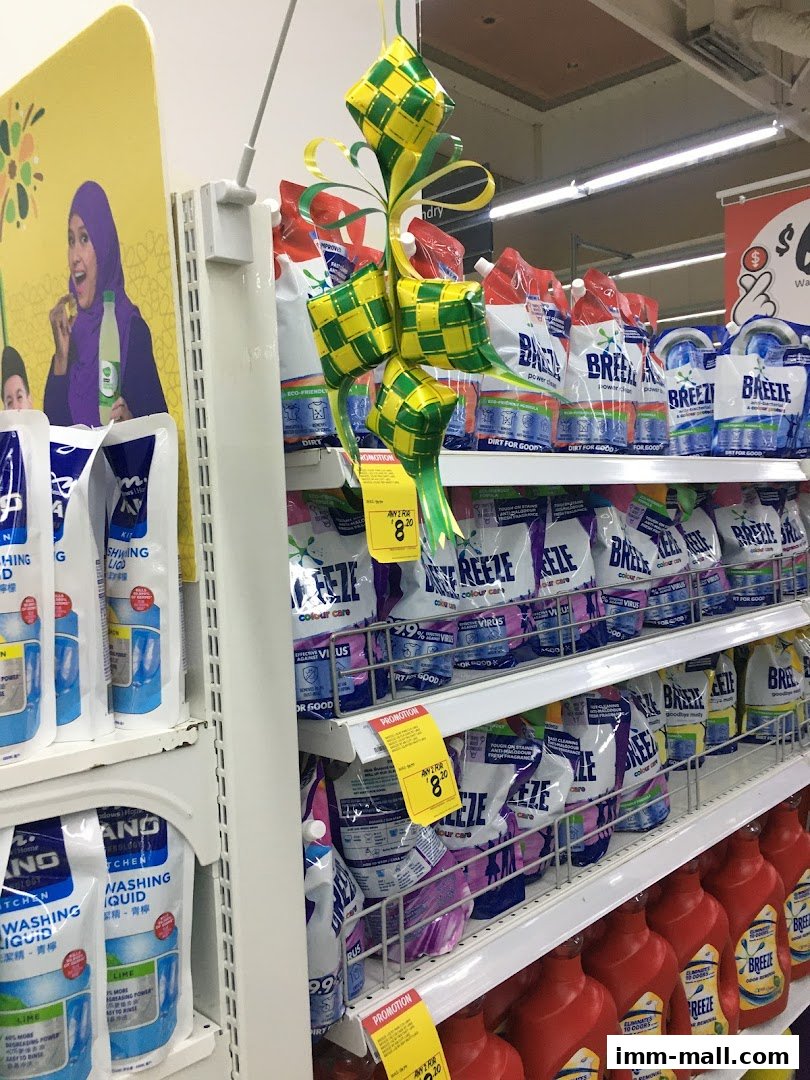 Shelves stocked with laundry detergent and dish soap, decorated with festive green and yellow diamond ornaments.