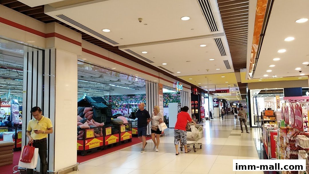 People shopping in a brightly lit supermarket aisle with various products on display.