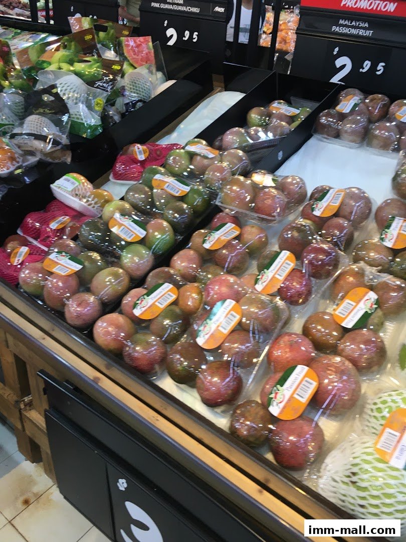 A display of fresh fruits, including passionfruit and guavas, at a supermarket.