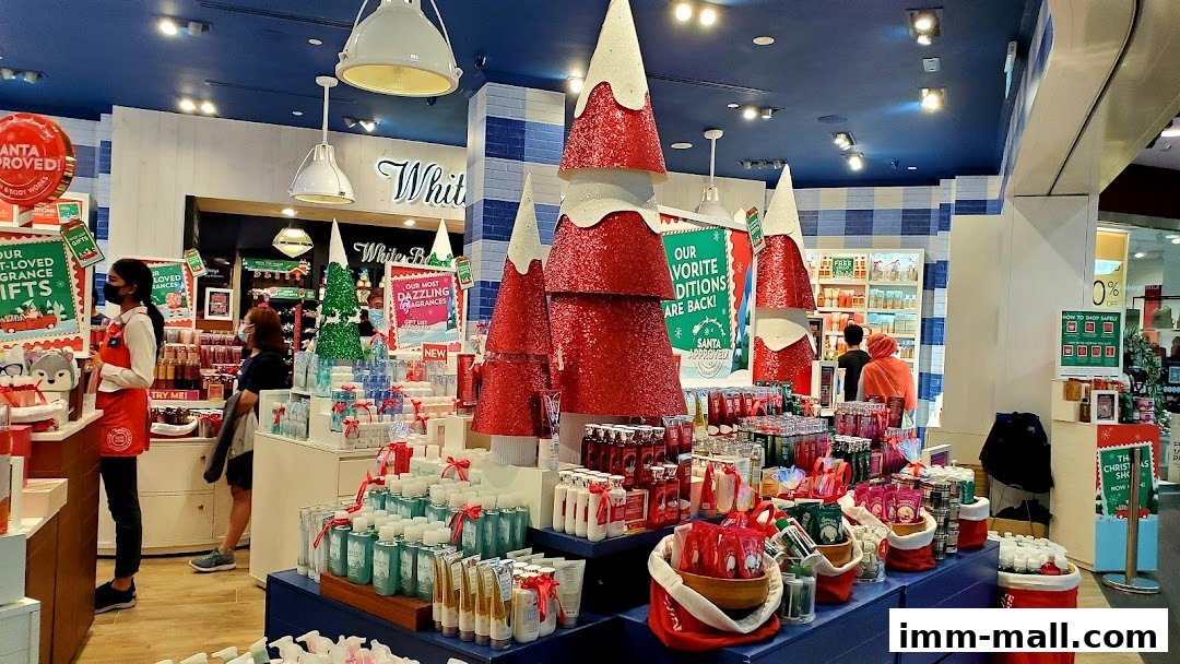 Interior of a Bath & Body Works store decorated for Christmas with festive displays and products.