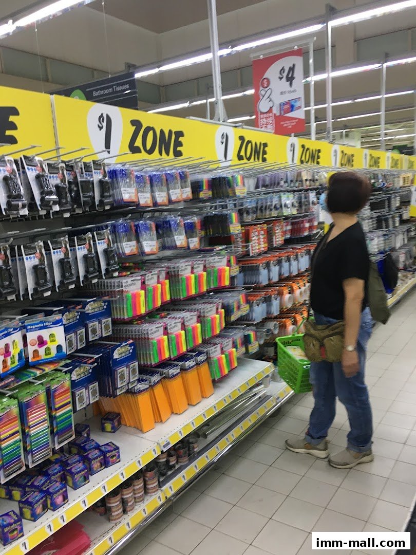 A shopper browses a well-stocked aisle of stationery and office supplies at Giant Supermarket.