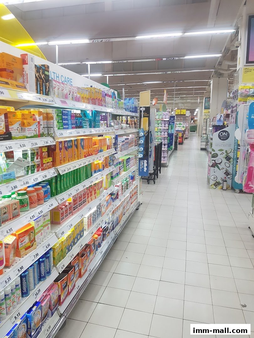Aisle view of a supermarket with shelves stocked with health and personal care products.