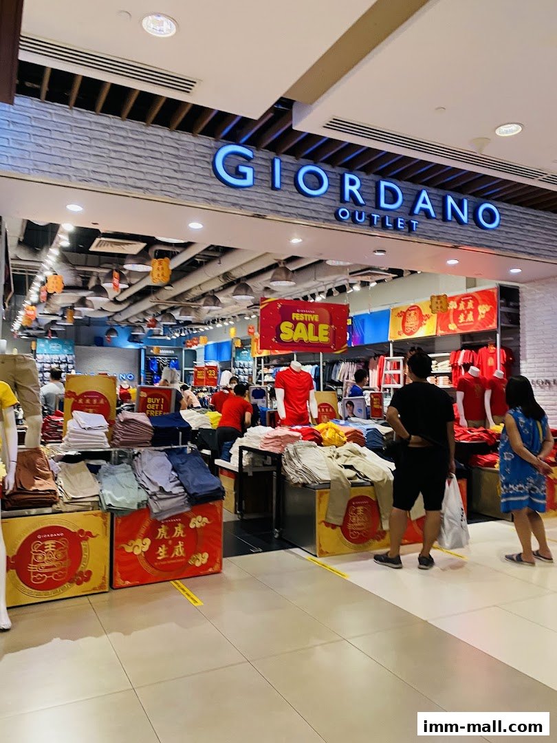 The entrance of Giordano Outlet with festive sale displays and clothing.