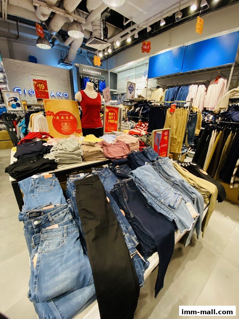 Interior view of a Giordano Outlet store showcasing folded jeans and apparel with sale signs.