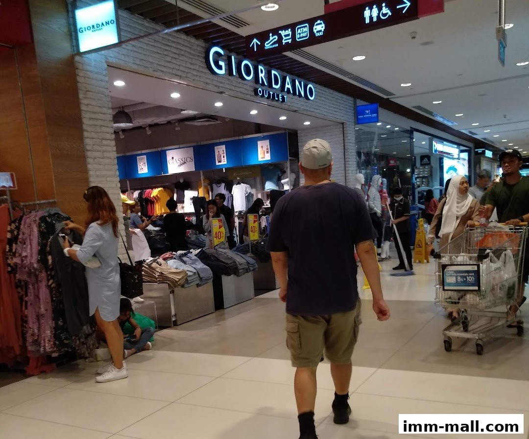 People shopping at Giordano Outlet, with clothing displays and signage visible.