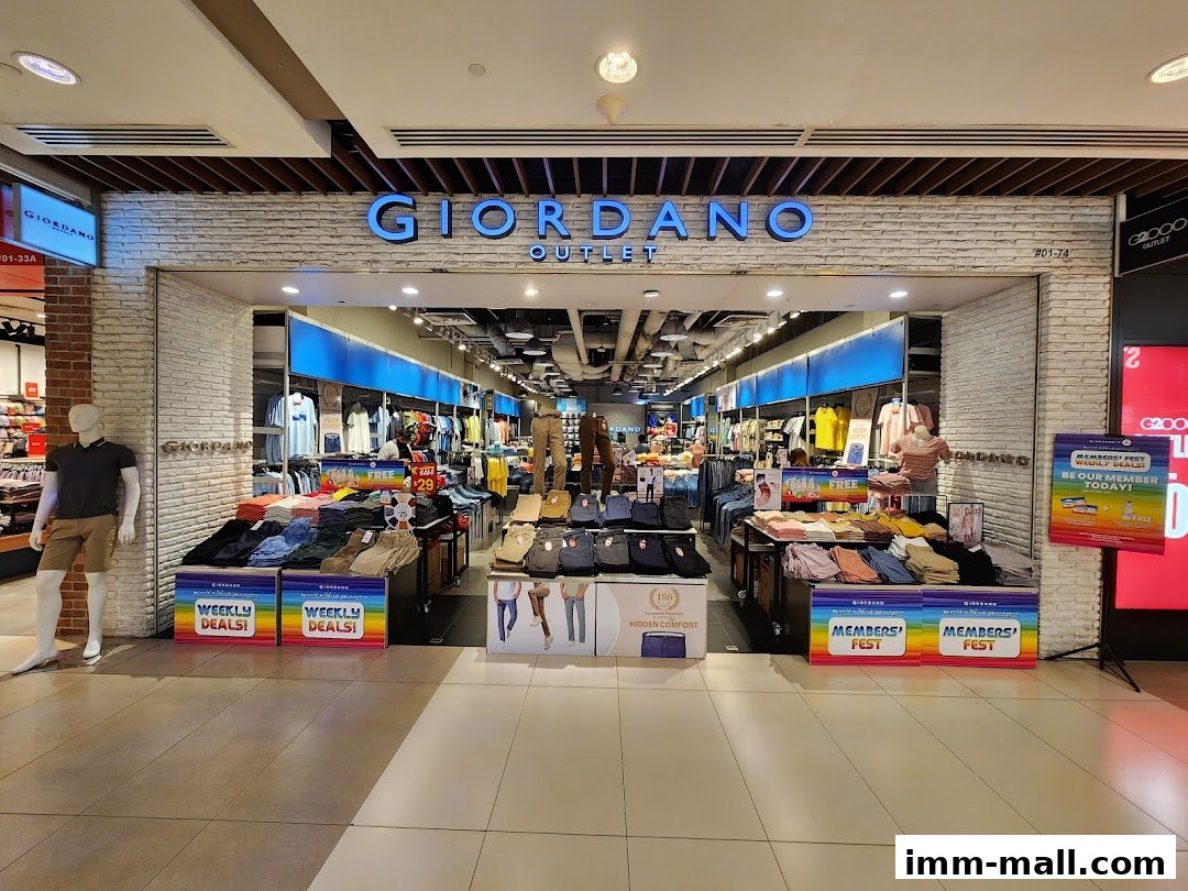The entrance of a Giordano Outlet store displaying clothing and promotional signs.