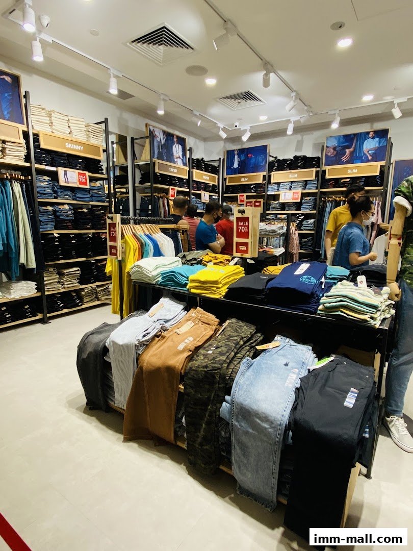 Interior view of a Giordano Outlet store showcasing various styles of jeans and t-shirts.