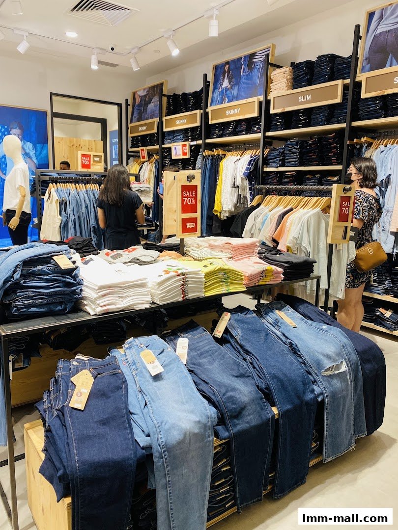Interior of a Giordano Outlet store showcasing a wide selection of jeans and t-shirts on display.