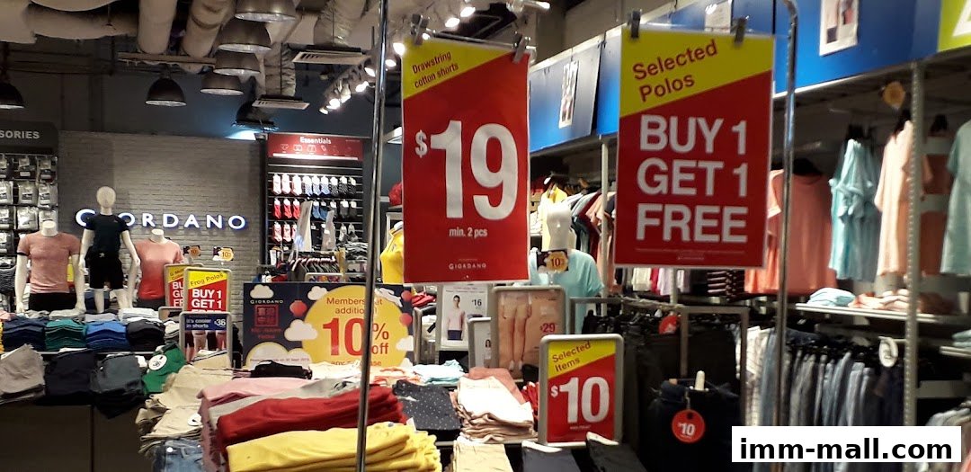 Giordano Outlet store interior with clothing displays and promotional signs.