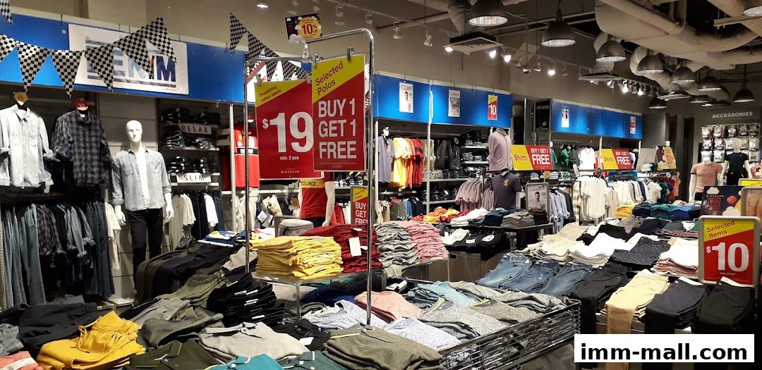 Interior view of a Giordano Outlet store showcasing various clothing items and promotional signage.