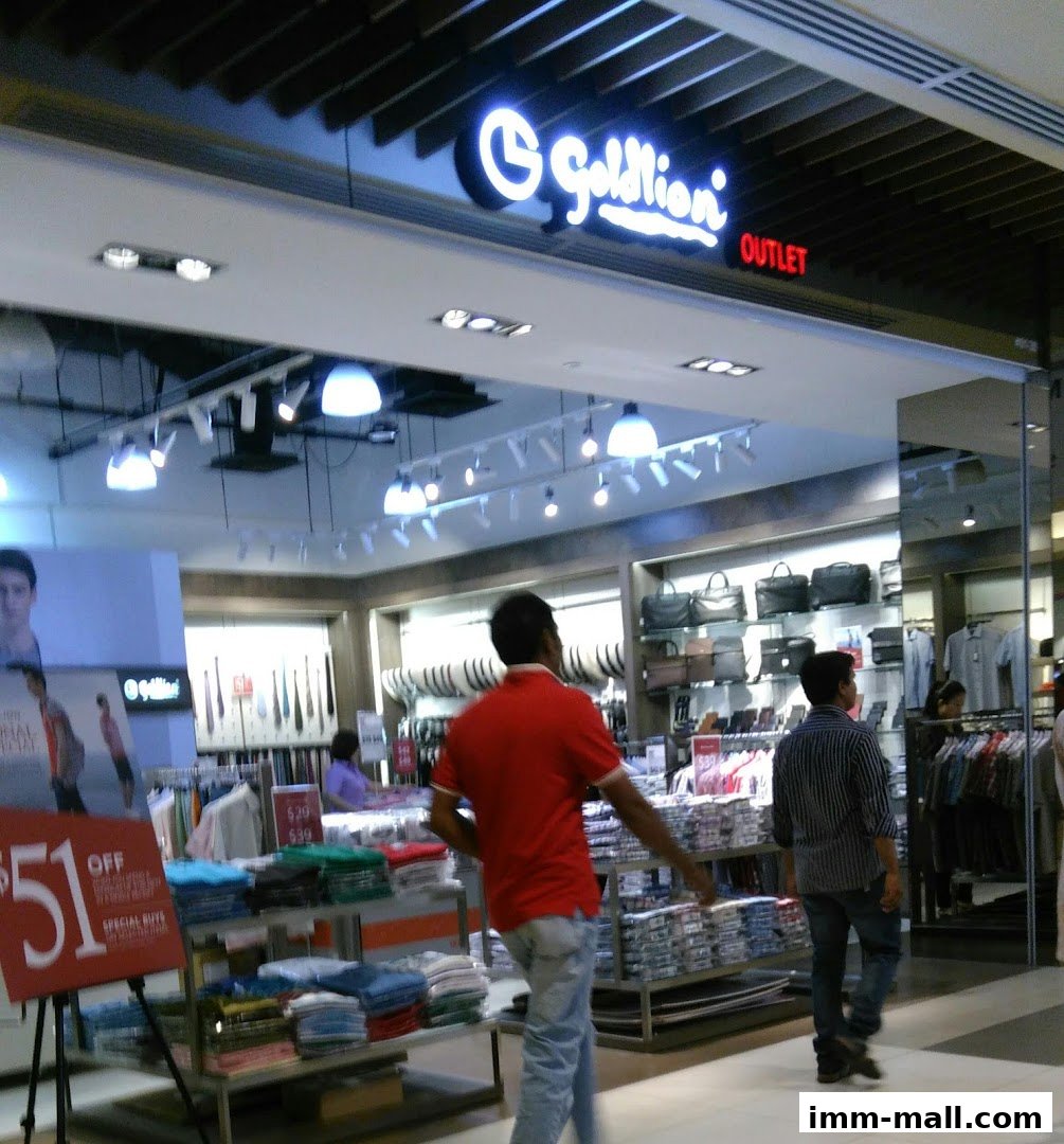 The Goldlion outlet store displays folded shirts and handbags, with shoppers browsing inside.