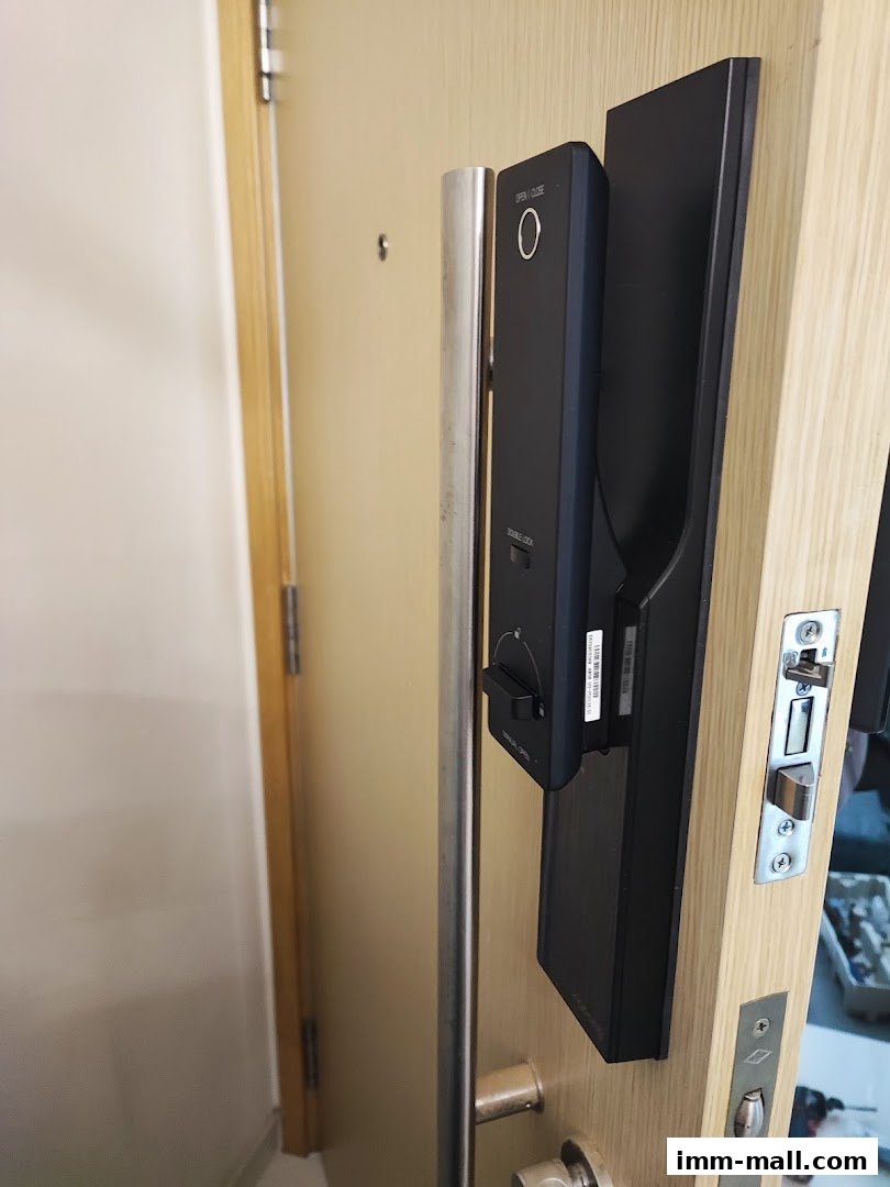 A close-up of a modern digital door lock installed on a wooden door.