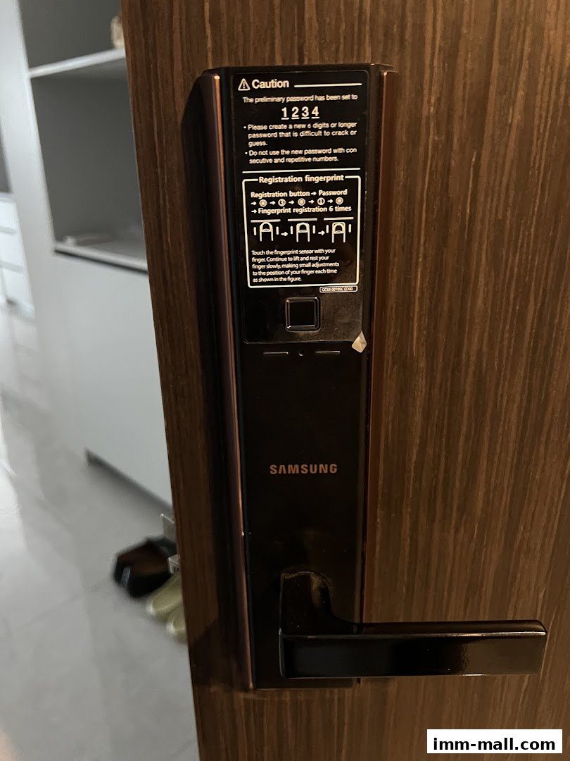 A close-up of a Samsung digital door lock with instructions for setting a password and registering fingerprints.