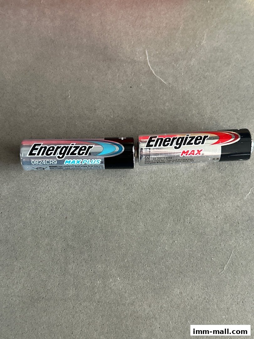 Two Energizer batteries, one Max Plus and one Max, are shown on a gray surface.