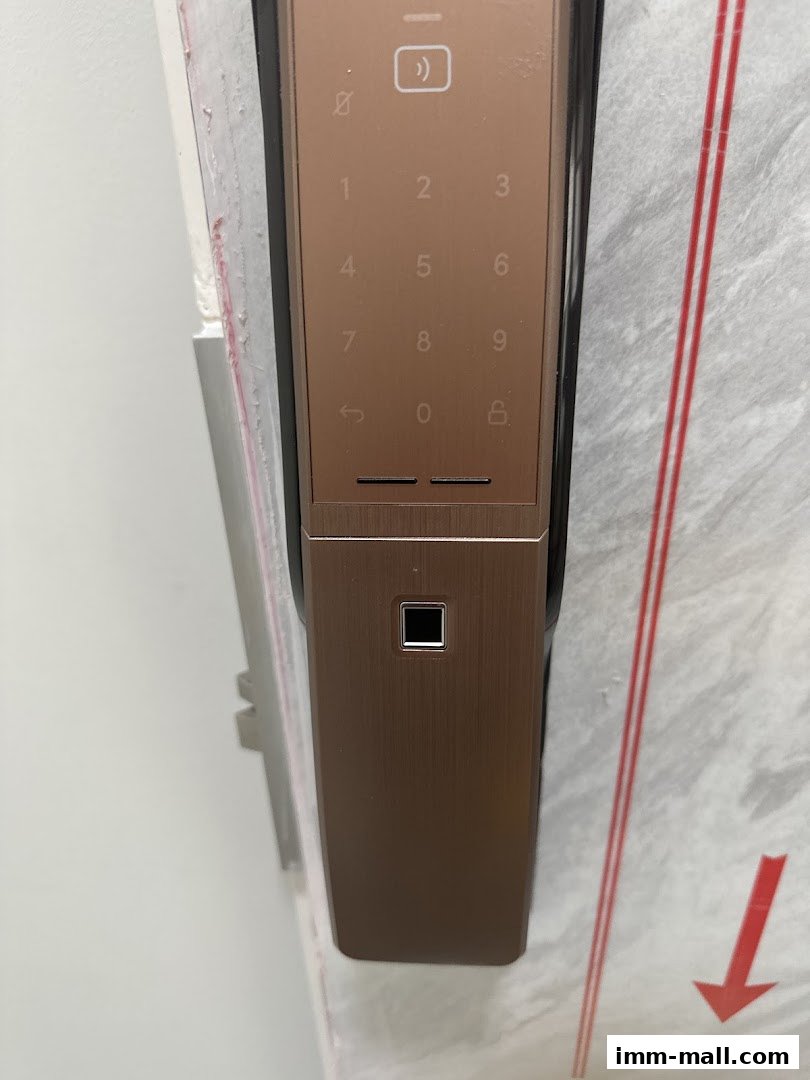 Close-up of a modern, bronze-colored smart door lock with a keypad and fingerprint scanner.