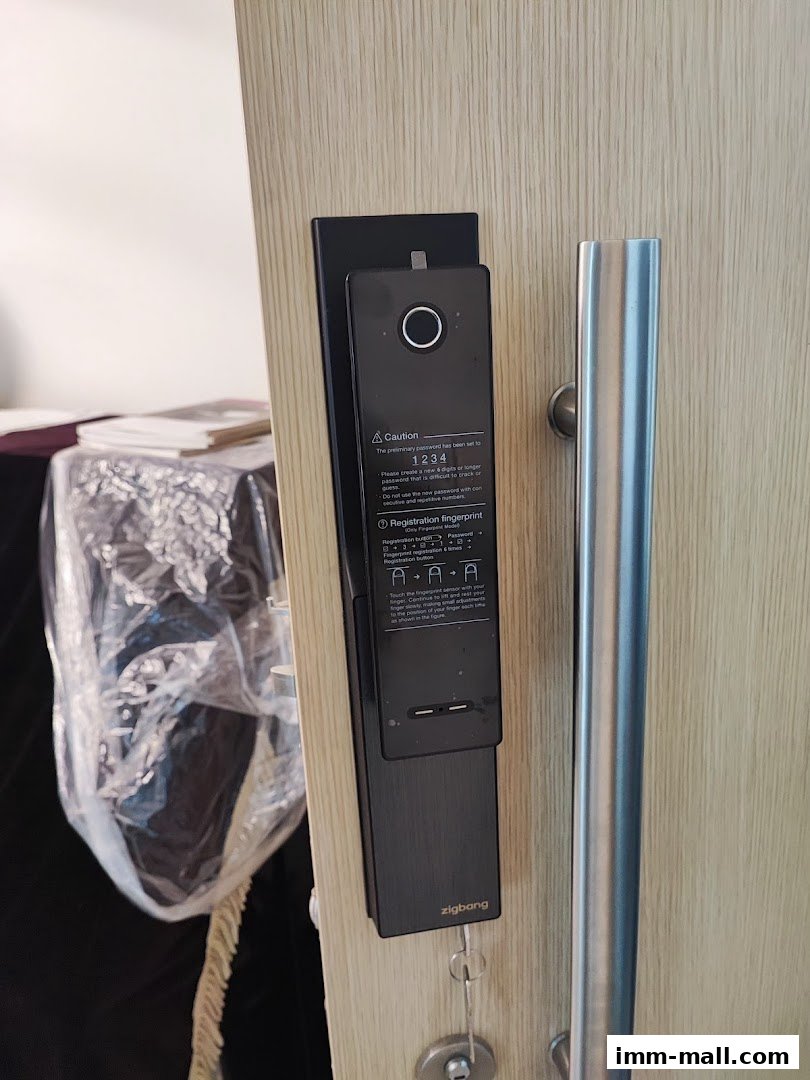 A close-up of a modern black digital door lock with a fingerprint scanner and handle.