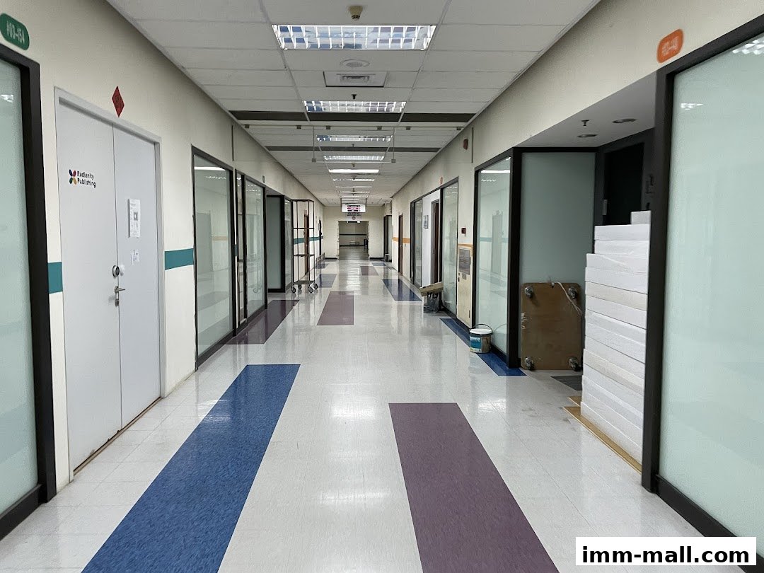 A long, empty office building hallway with doors and windows on both sides.