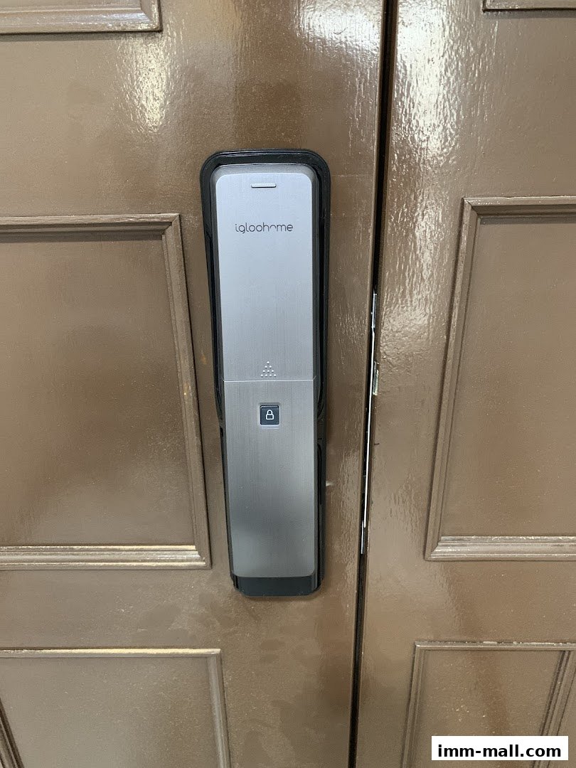 A close-up of a modern digital door lock with the Igloohome logo on a brown door.