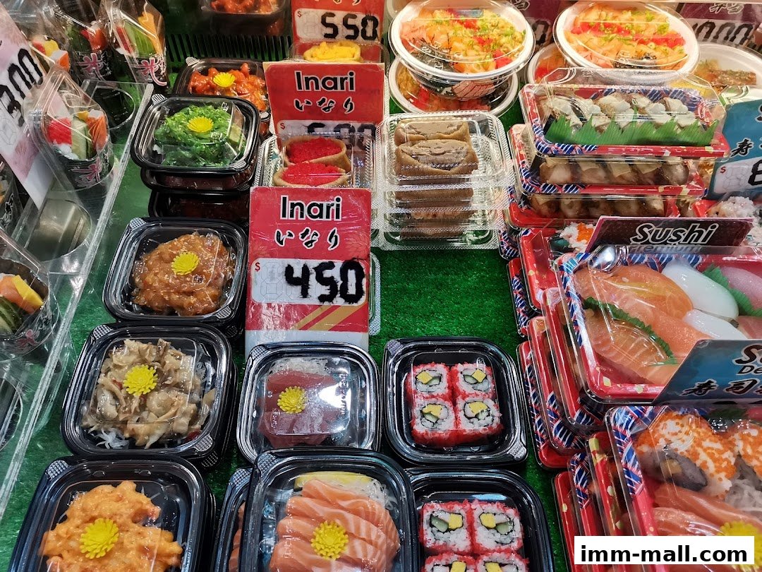 A display of various sushi and Japanese food items in plastic containers.