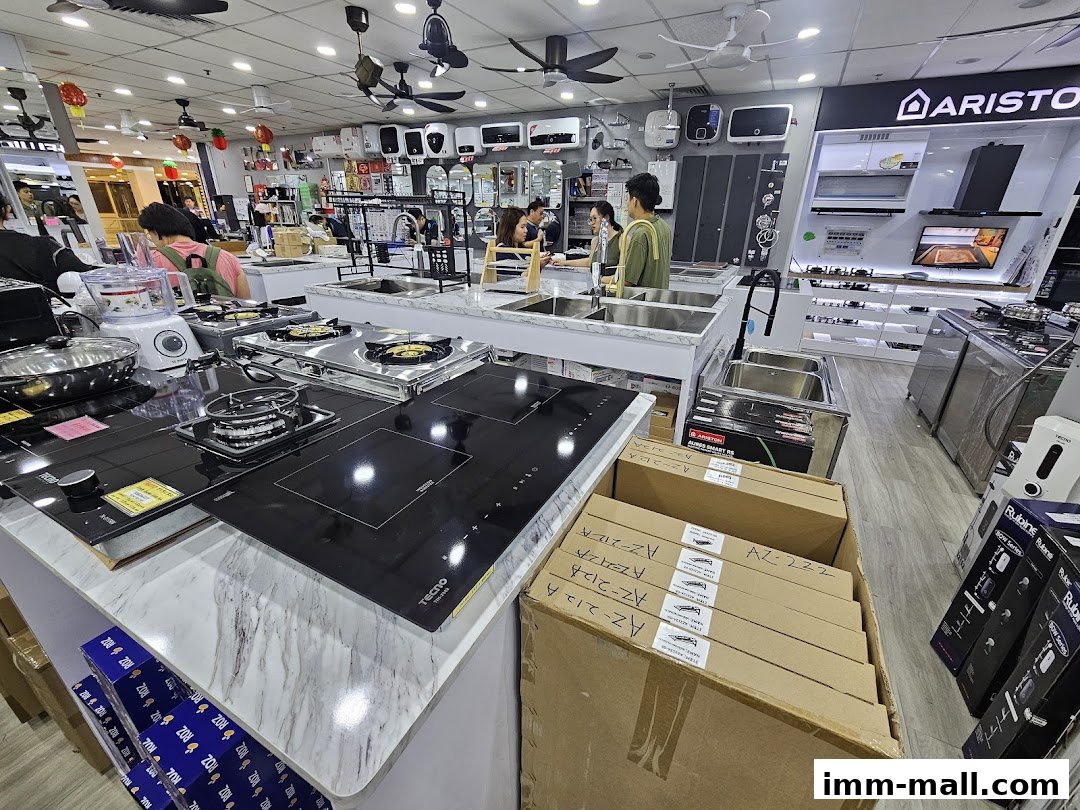 Interior view of a hardware showroom displaying kitchen appliances like induction cooktops and sinks.