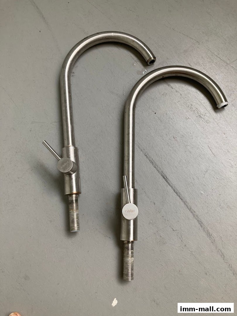 Two stainless steel faucets with curved spouts and lever handles are displayed on a gray surface.