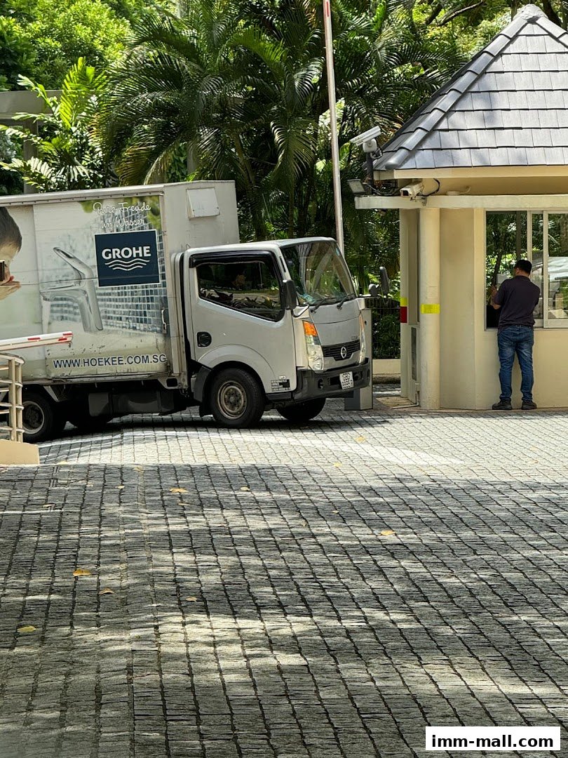 A delivery truck with Grohe branding parked near a security booth.