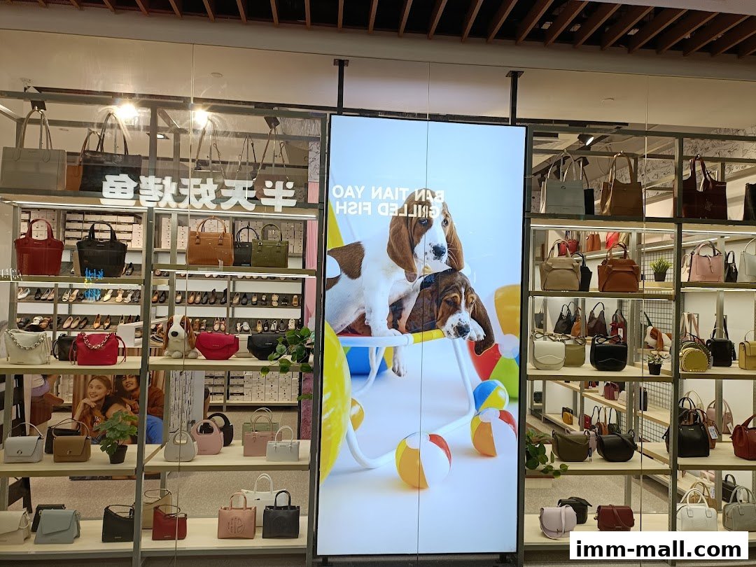 A well-lit display of Hush Puppies footwear and bags, featuring a digital screen with dogs.