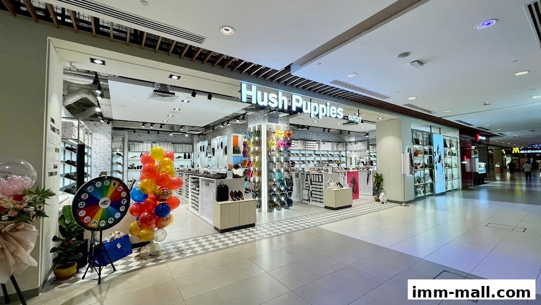 The Hush Puppies Footwear & Bags Outlet store entrance with colorful balloons and a prize wheel.