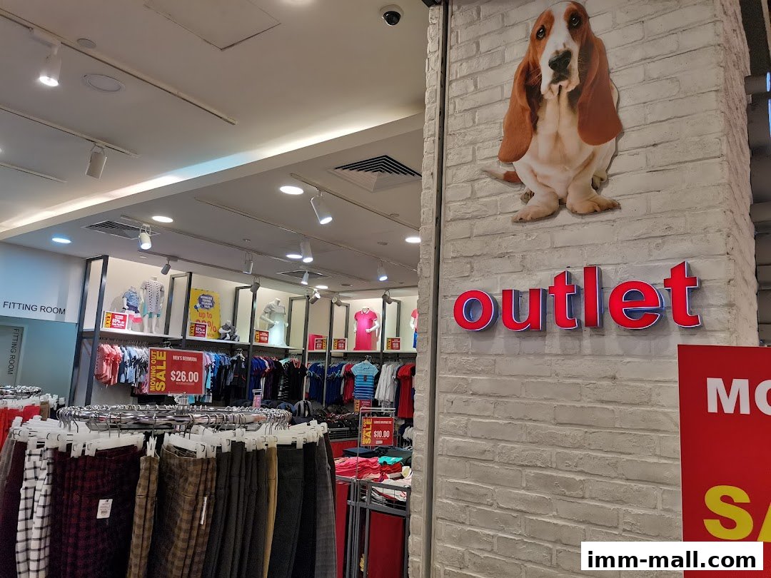 Hush Puppies outlet store interior with clothing racks and signage.