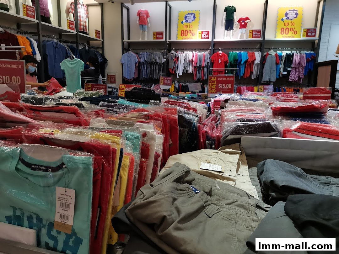 Interior view of a Hush Puppies store with clothing displays and sale signs.
