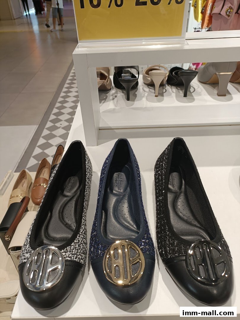 A display of stylish Hush Puppies flat shoes with decorative emblems.