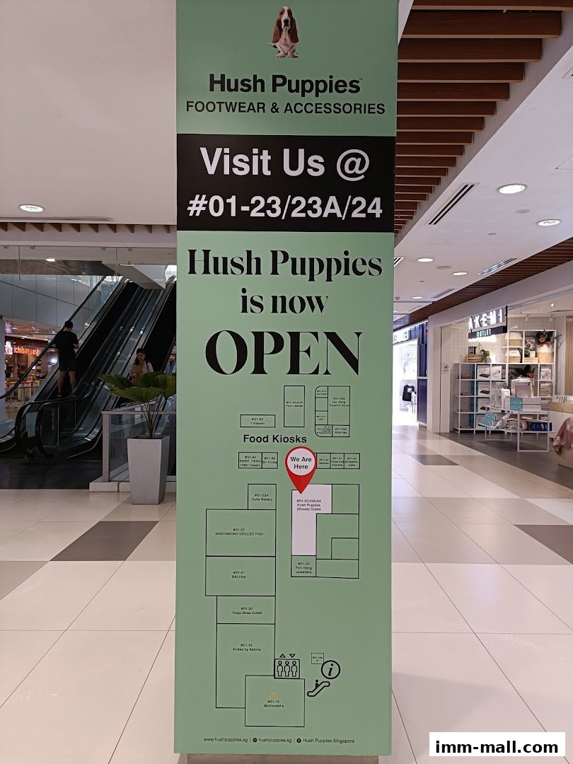 A sign for Hush Puppies Footwear & Accessories indicating their location and opening status.