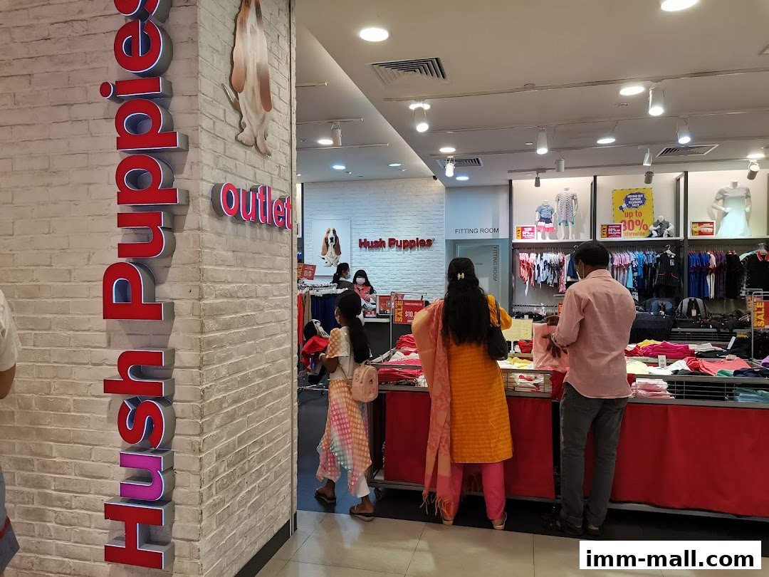 Customers browsing clothing and accessories at a Hush Puppies outlet store.