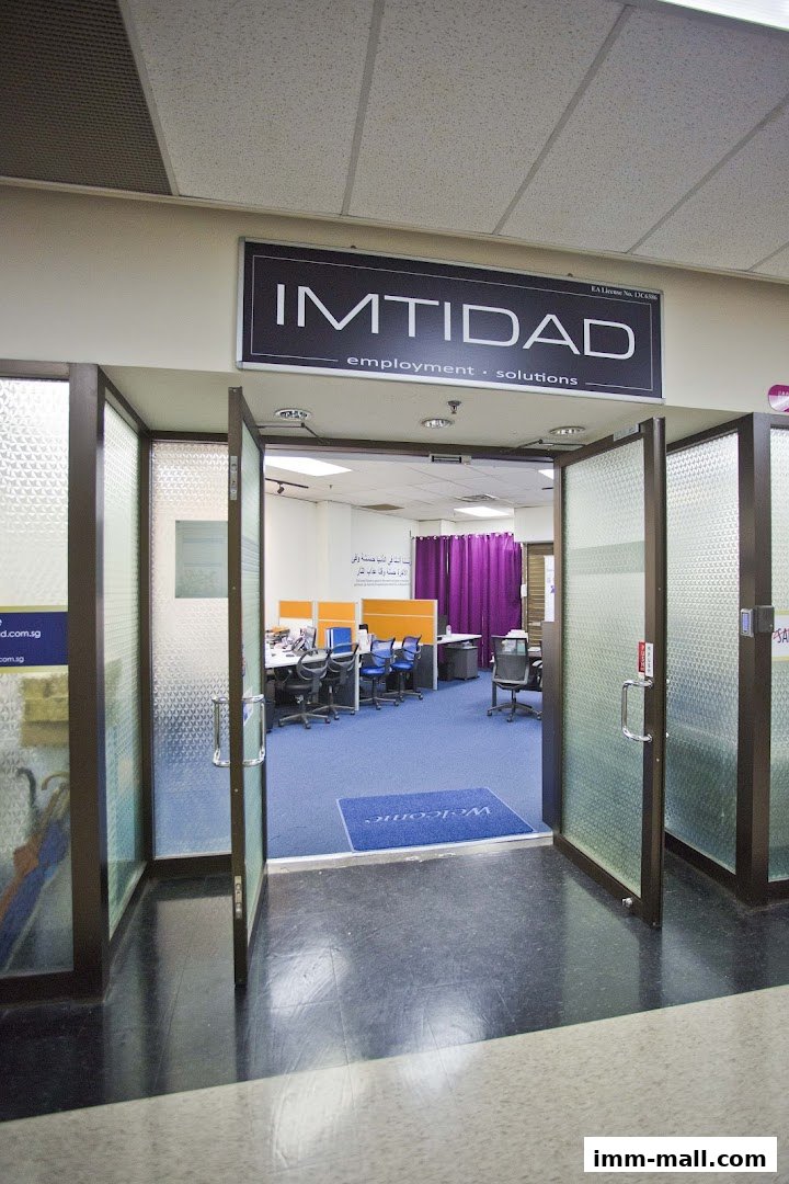 The entrance to Imtidad, an employment and solutions office, with open glass doors revealing the interior.