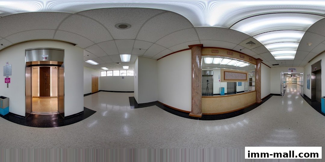 Interior view of a mall hallway with elevators and a reception area.